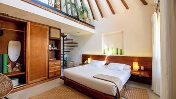 Un dormitorio con una cama grande, un armario de madera y un balcón con plantas.
