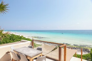 Una terraza con mesa y sillas con vista a la playa.