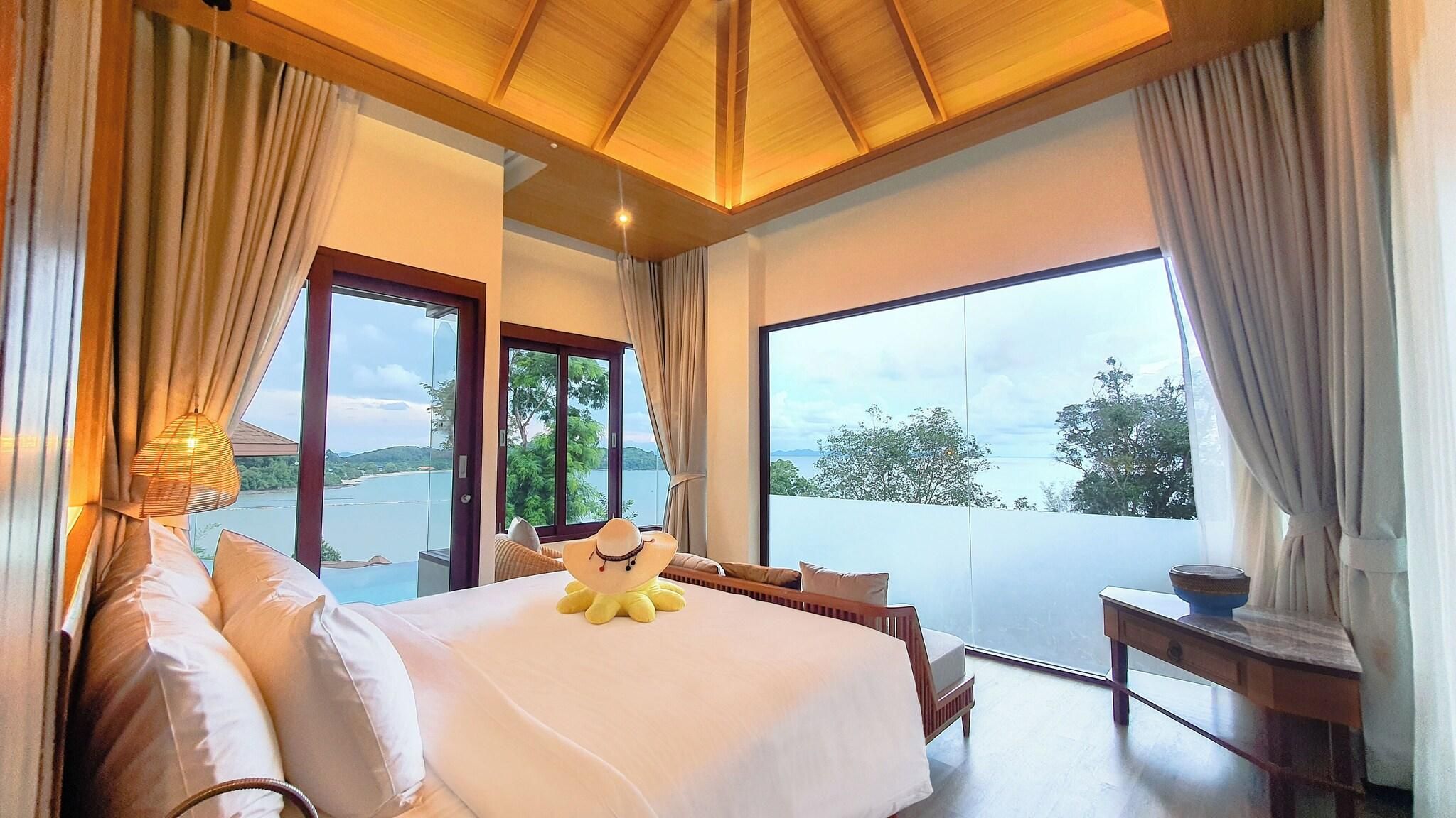 A bedroom with a large bed, a view of the sea, and a balcony.