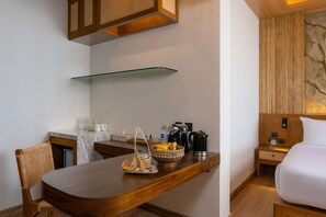 Een moderne keuken met een houten tafel, een koffiezetapparaat en een mand met fruit.