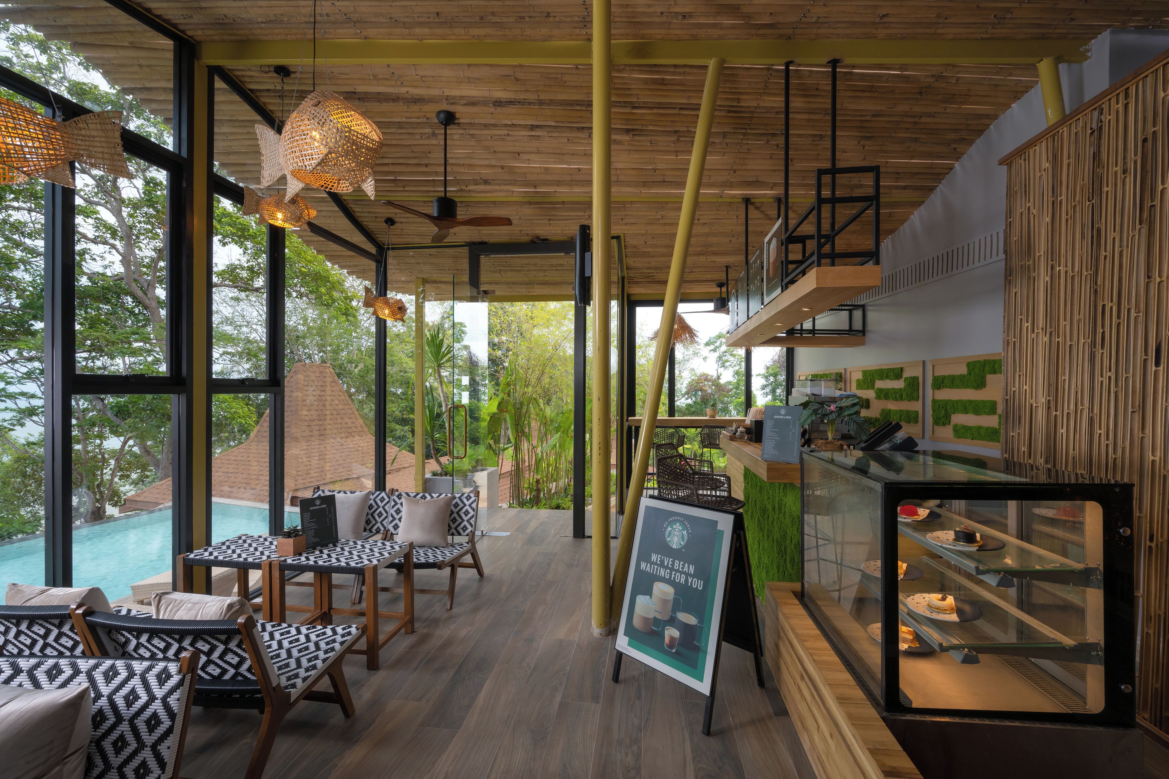 Un intérieur moderne avec un coin repas, un plafond en bois et une vue sur une piscine.