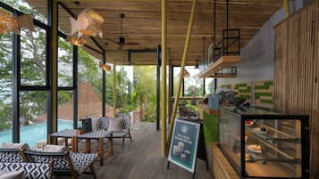 Un intérieur moderne avec un coin repas, un plafond en bois et une vue sur une piscine.