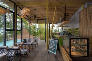 Een modern interieur met een eethoek, houten plafond en uitzicht op een zwembad.