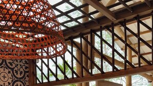 A bar area with a view of the outdoors, featuring a bamboo structure, a patterned wall, and various bottles. - RINCON DEL MANGLE (San Onofre)