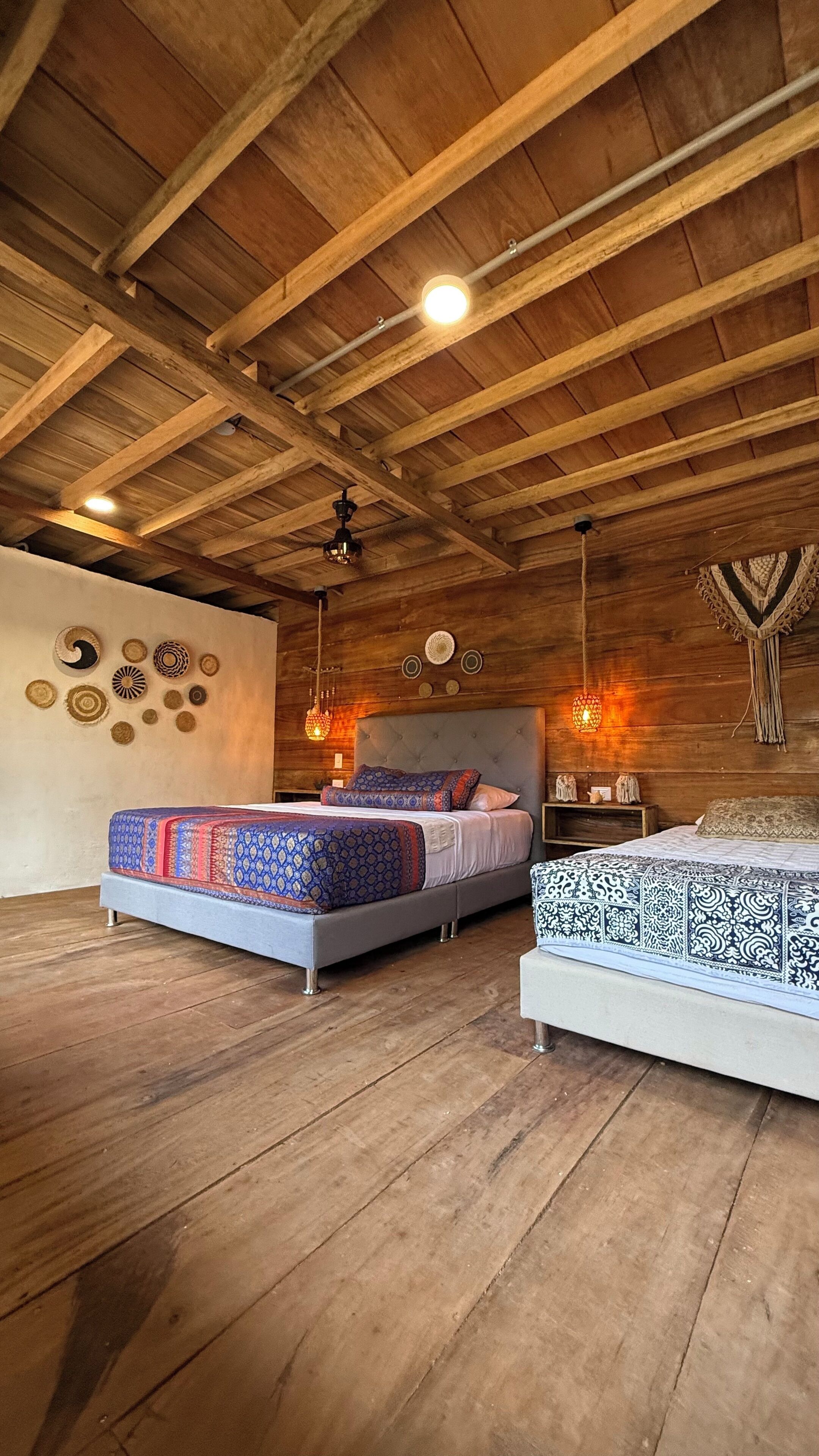 Un dormitorio rústico con dos camas, vigas de madera en el techo y decoración en la pared.