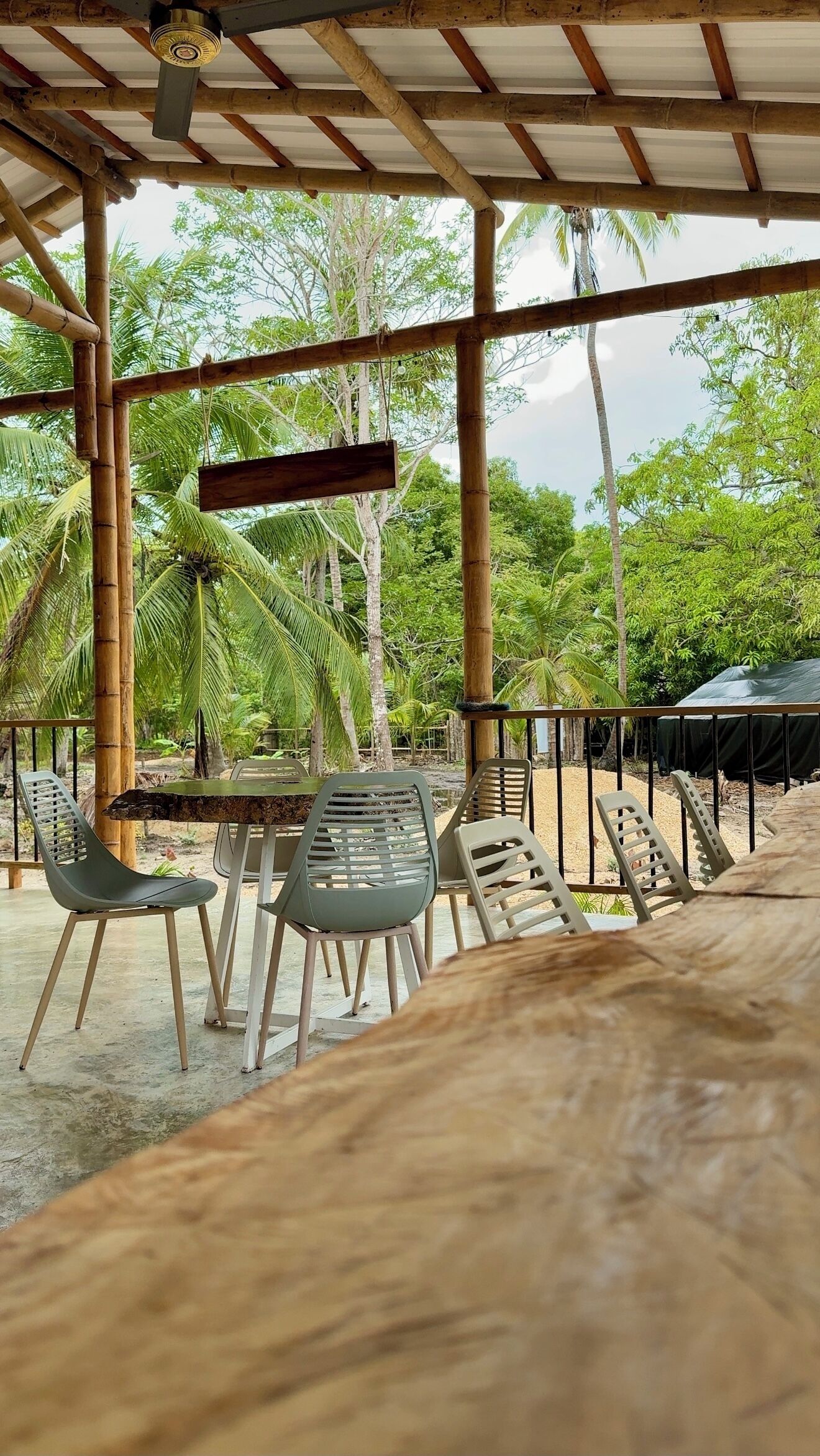 An outdoor seating area with bamboo structures, tables, and chairs.