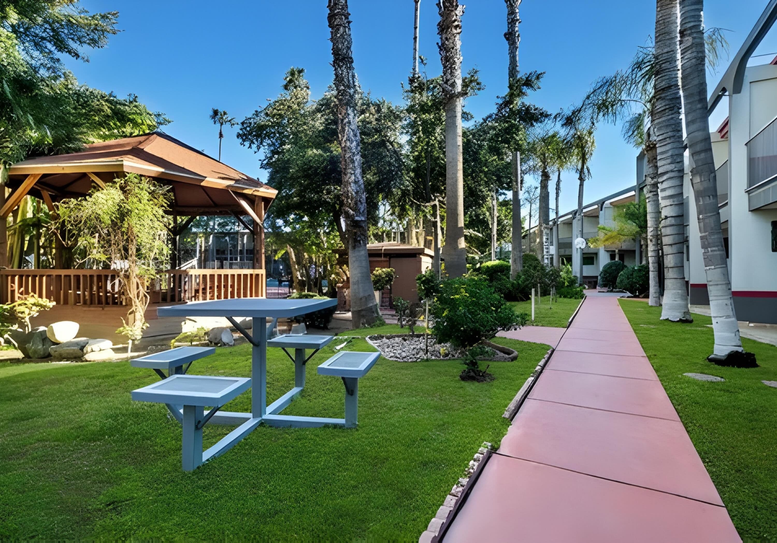 A patio area with a wooden pergola, a table, and benches.