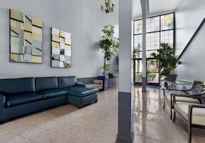 Una sala moderna con un sofá modular, una mesa de centro de vidrio y arte abstracto en la pared.