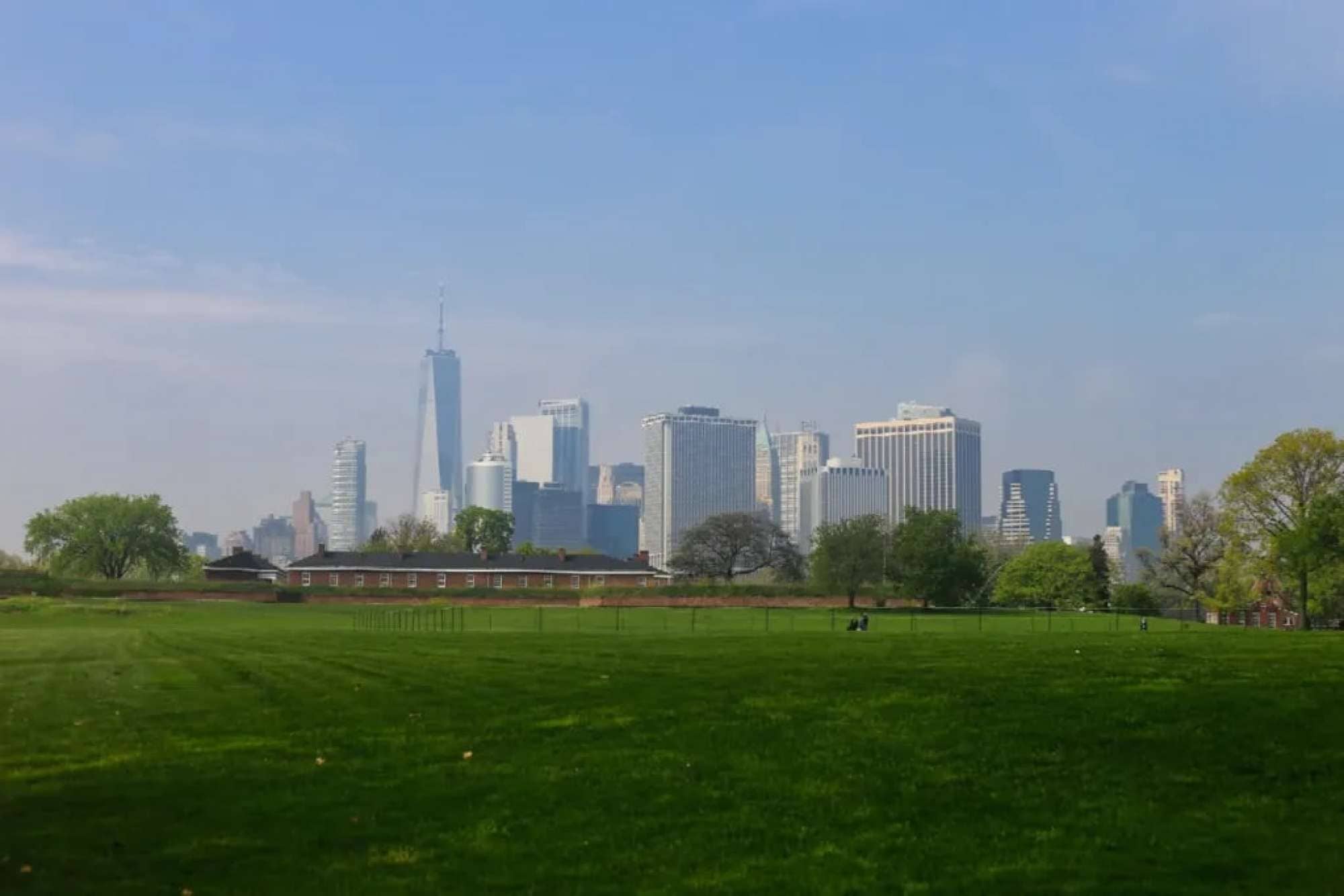 Un horizonte urbano con edificios modernos y un parque grande y verde al frente.
