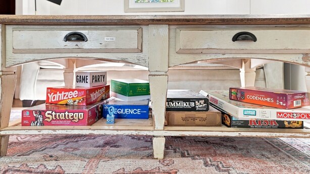 Un escritorio de madera con cajones que guardan varios juegos de mesa.