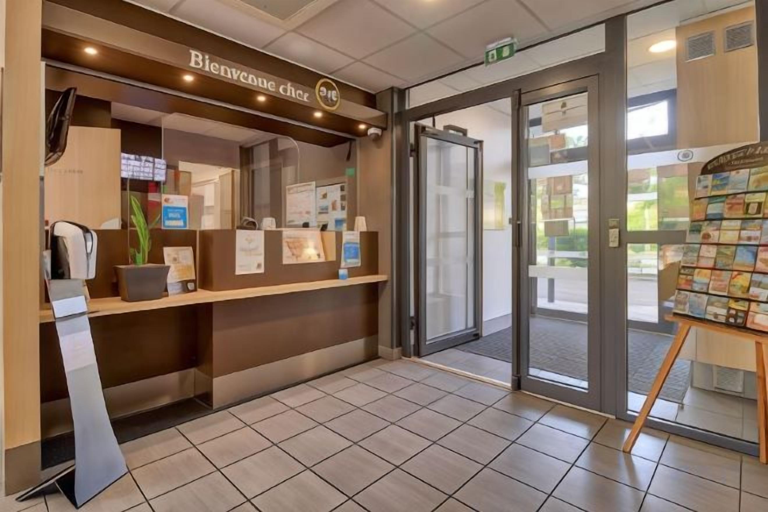 A reception area with a counter, a coffee machine, and a display of brochures.