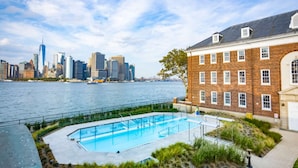 A swimming pool with a city skyline in the background. - Canvas Retreats | Morning Yoga | City Escapes (New York)
