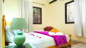 A room with a bed, a green lamp, and a window with a metal gate. - Riad Qodwa (Sidi Abdallah Ghiat)