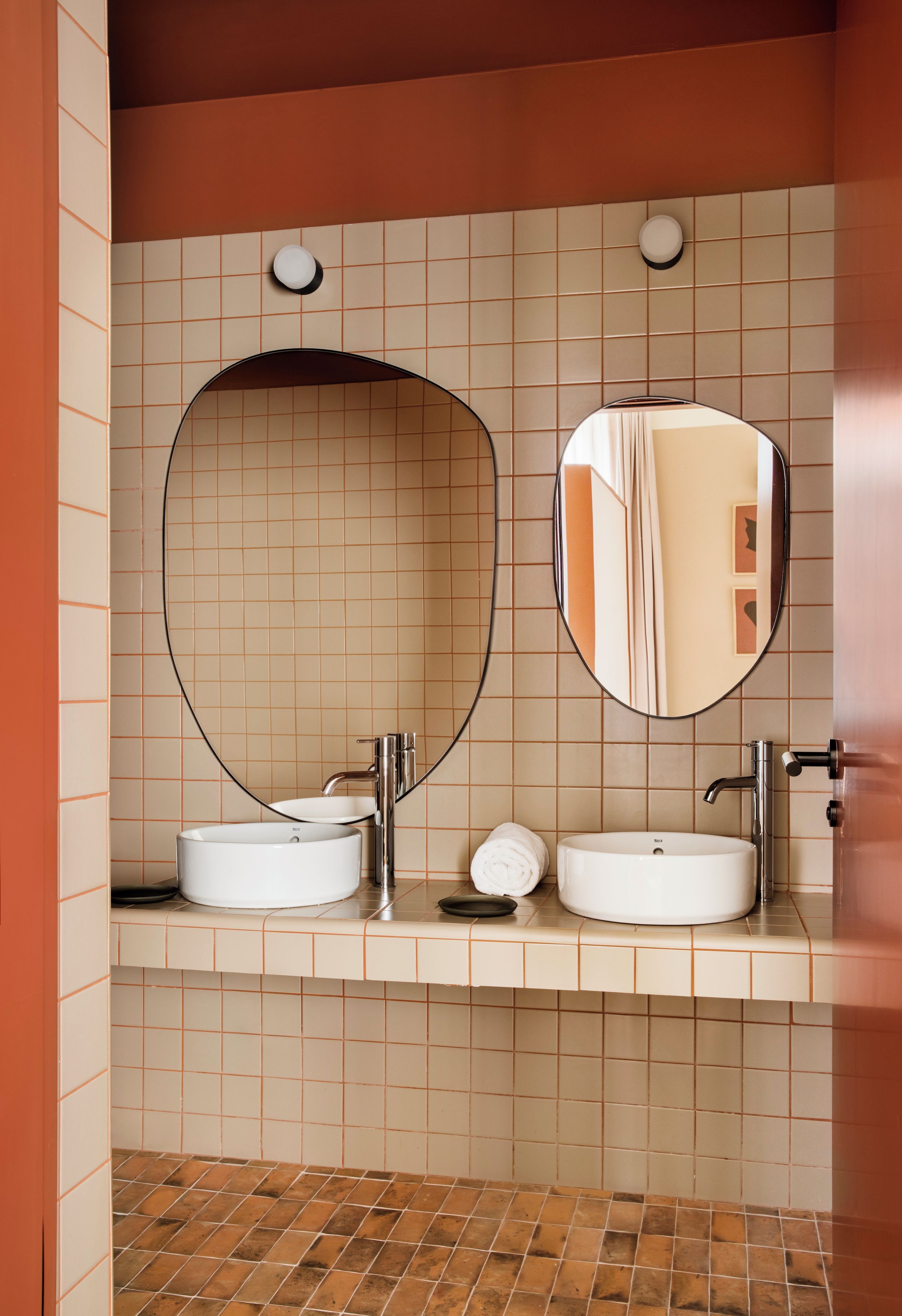 Un baño con dos lavamanos, una toalla y un espejo.