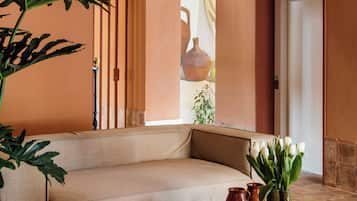 Una sala de estar acogedora con un sofá, una mesa redonda de madera y una planta en maceta.