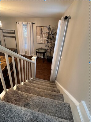A staircase with carpeted steps leading to a landing. - Relax and Roscoe Apartment (Coshocton)
