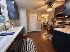 A modern kitchen with dark cabinets, a white countertop, and a built-in oven. - Relax and Roscoe Apartment (Coshocton)