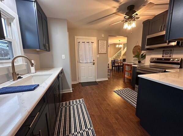 A modern kitchen with dark cabinets, a white countertop, and a built-in oven.