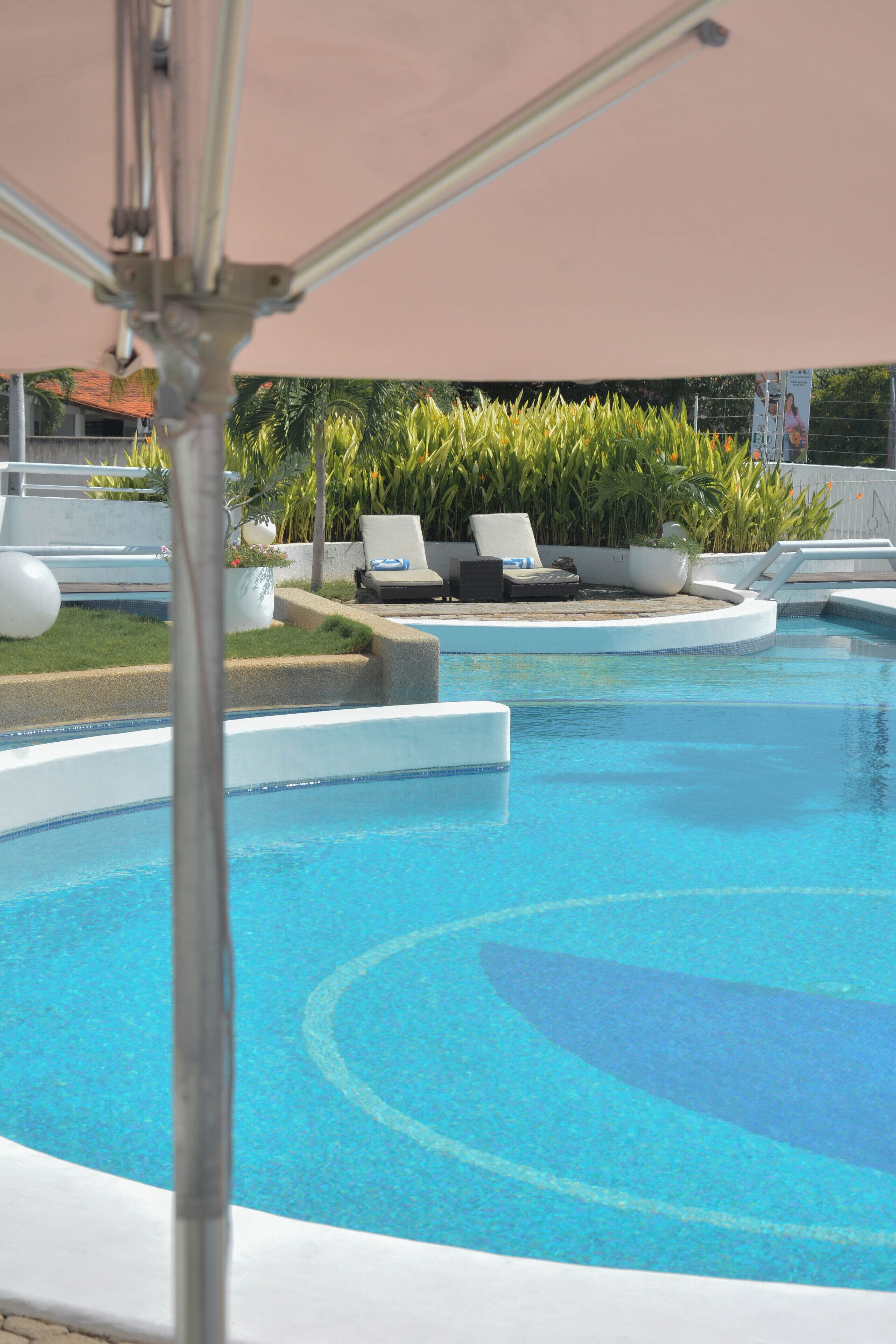 A swimming pool with lounge chairs and planters.
