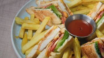 Um prato de sanduíches e batatas fritas com um pequeno recipiente de ketchup.