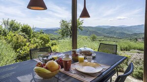 A table set with breakfast items, overlooking a mountainous landscape.