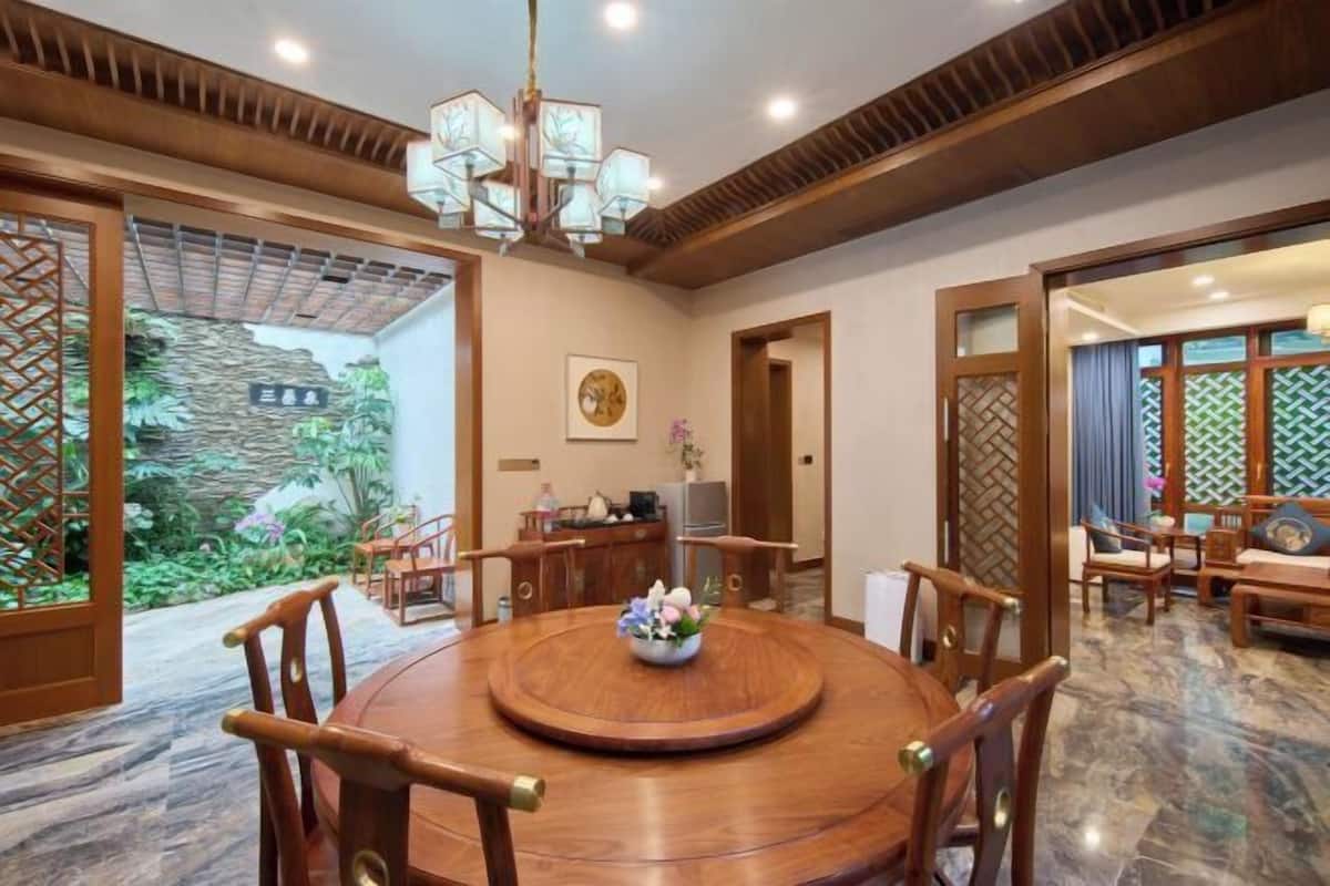 Un coin repas de style traditionnel, avec une table ronde en bois, des chaises et un lustre.