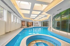 Una piscina interior con tragaluces y paredes de vidrio.