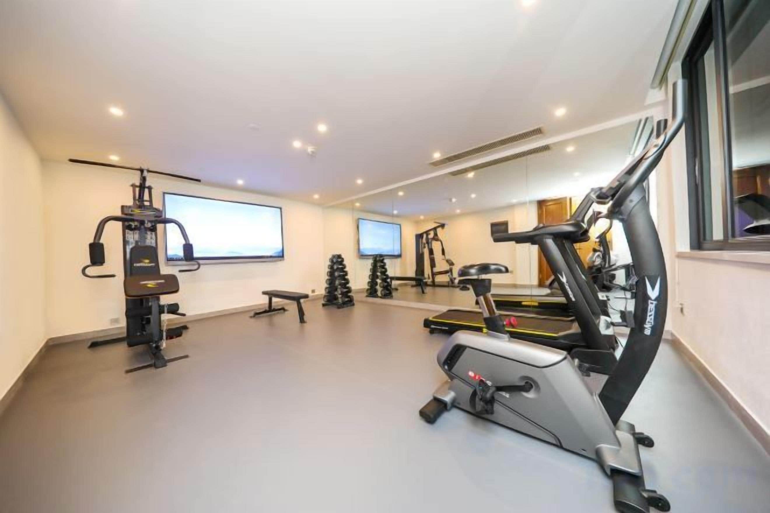 Un gimnasio en casa con equipo de ejercicio, una cinta de correr y una bicicleta estática.