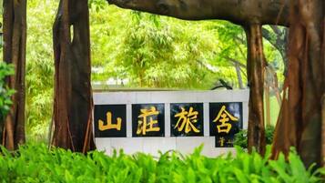 A sign with Chinese characters, surrounded by greenery.