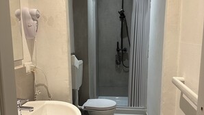 Un baño moderno con lavamanos, inodoro y zona de ducha.