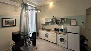 Una cocina funcional con comedor, lavadora y refrigerador.