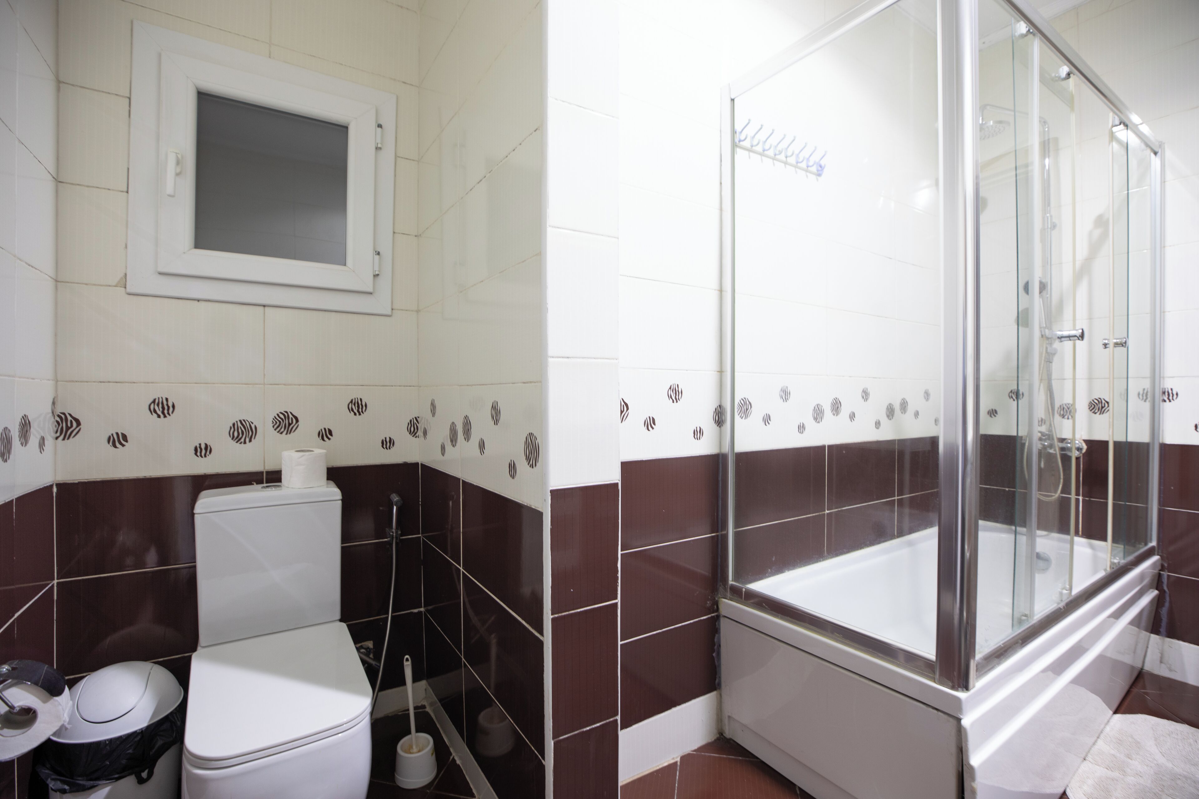 A bathroom with a toilet, bidet, and a glass-enclosed shower area.