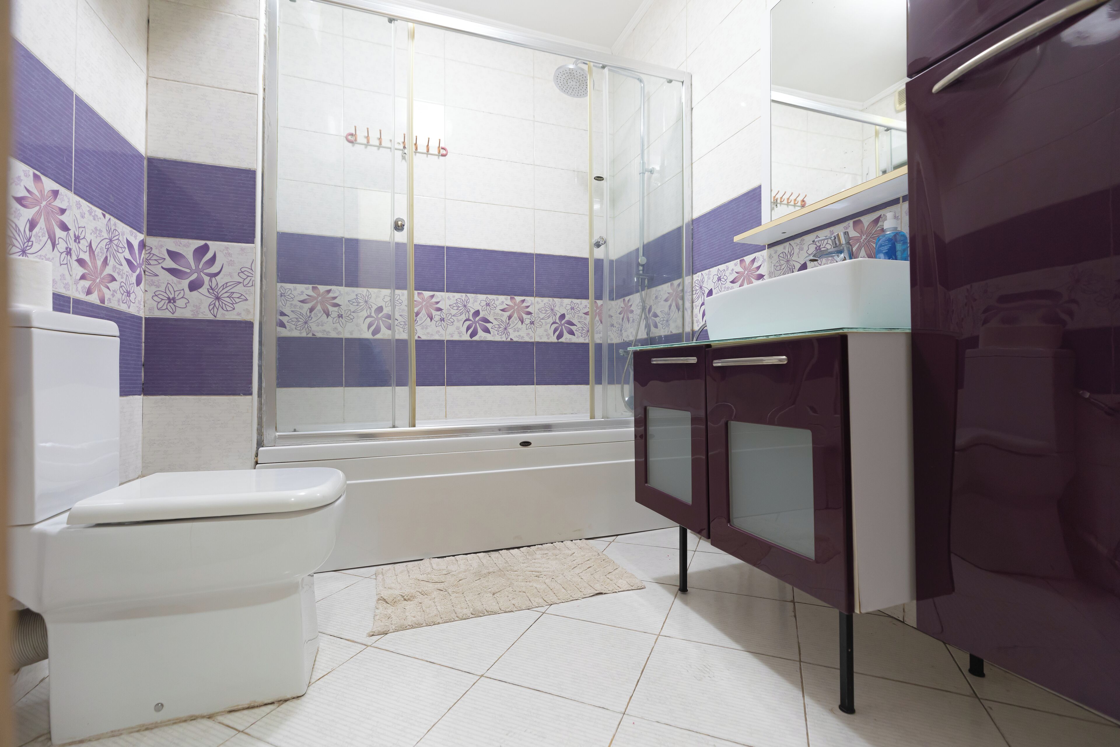 Een badkamer met toilet, douche, bad en een wastafel met spiegel.