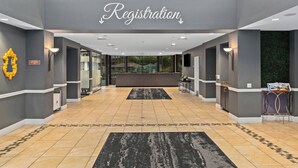 A registration area with a reception desk, a sign above it, and a view of the outdoors through glass doors. - Indio Resort Condos by WorldMark (Indio)