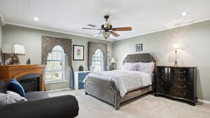 Une chambre à coucher avec un lit, une commode et un ventilateur de plafond.