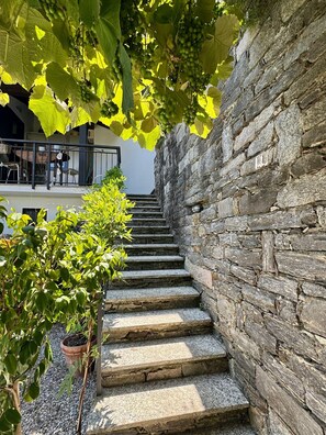 A stone staircase leading up to a balcony with a view of a building.