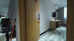 Une chambre d’hôtel avec une porte en bois, un bureau et un téléviseur.