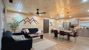 A cozy cabin interior with a living room, dining area, and kitchen.