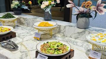 Un buffet proposant divers plats et agrémenté de compositions florales.