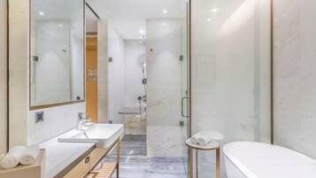 A modern bathroom with a glass-enclosed shower, a vanity with a mirror, and a bathtub.