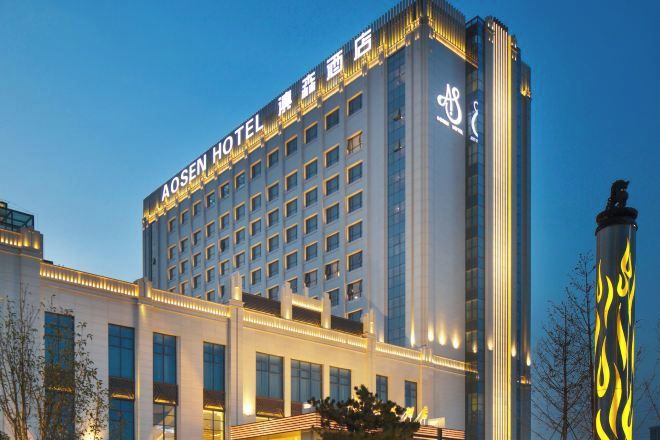 A multi-story hotel building with a prominent sign at the top.