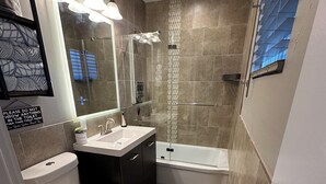 A modern bathroom with a toilet, sink, and shower. - Modern Escape (Loa)