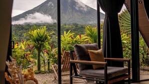 Un intérieur moderne doté d’une grande fenêtre offrant une vue sur une montagne et une végétation luxuriante.