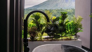 Une salle de bain avec une baignoire, une fenêtre et une vue sur la montagne.
