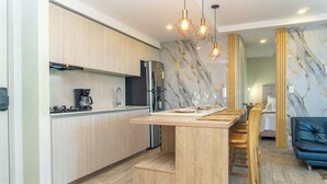 Een moderne keuken met houten kastjes, een centraal eiland en een marmeren achterwand.