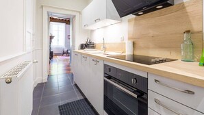 Una cocina moderna con horno empotrado, microondas y una campana extractora negra.