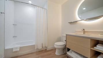 A modern bathroom with a shower, toilet, and vanity.