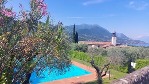 Zona de piscina con vista despejada a una montaña e iglesia con campanario.