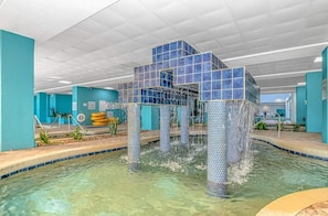 A pool area with a tiled structure in the center, surrounded by a clear pool.