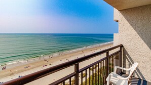 A balcony with a view of a beach and ocean.